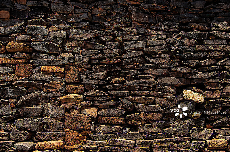 古老的橙色和棕色堆叠石材环绕墙图片素材