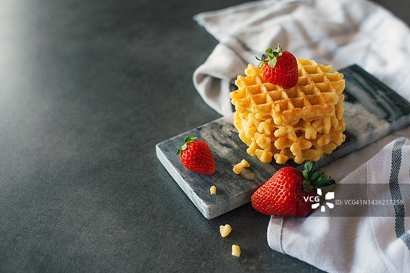 灰色背景上可爱的小华夫饼。甜点。上菜。甜蜜美味的食物。图片素材