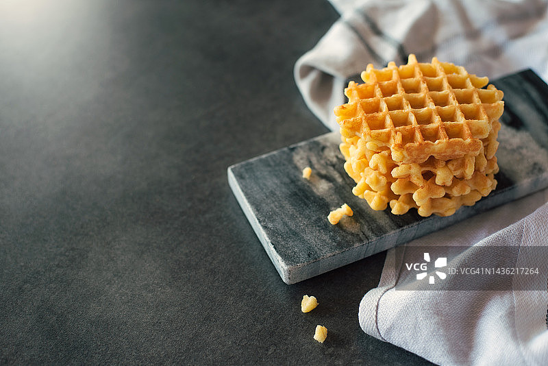 灰色背景上可爱的小华夫饼。甜点。上菜。甜蜜美味的食物。图片素材