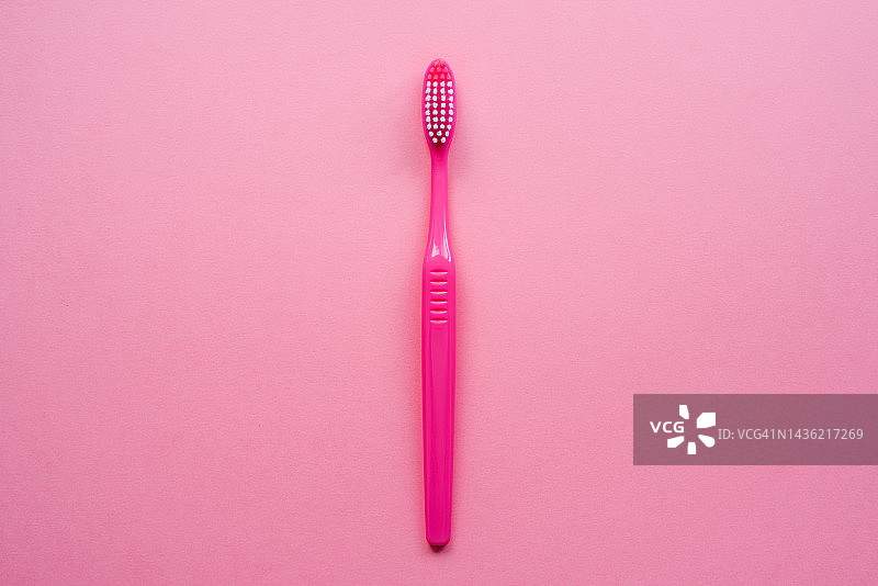 粉色背景上的牙刷：口腔护理与牙齿健康图片素材