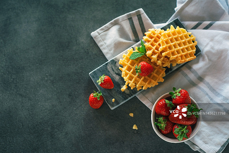 灰色背景上可爱的小华夫饼。甜点。上菜。甜蜜美味的食物。图片素材