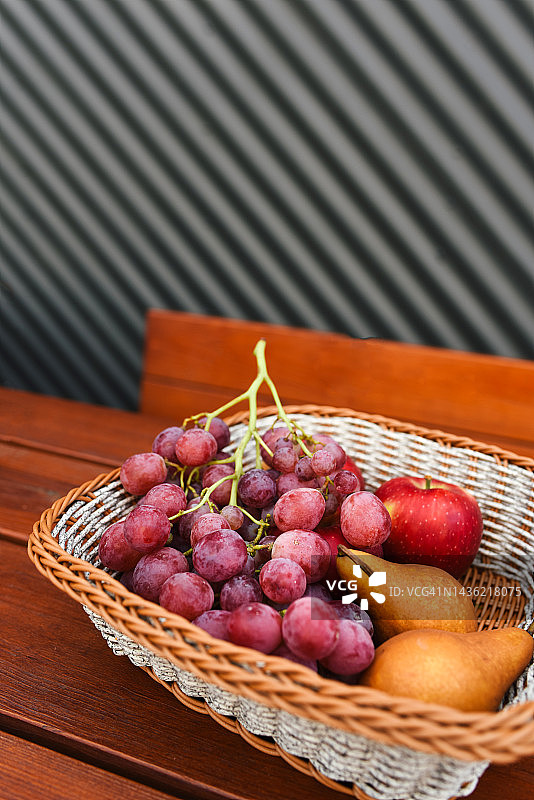 木桌上柳条篮中的秋季水果图片素材