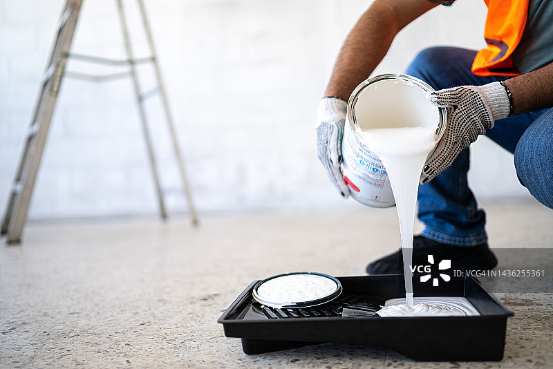 油漆工人在室内倾倒油漆图片素材