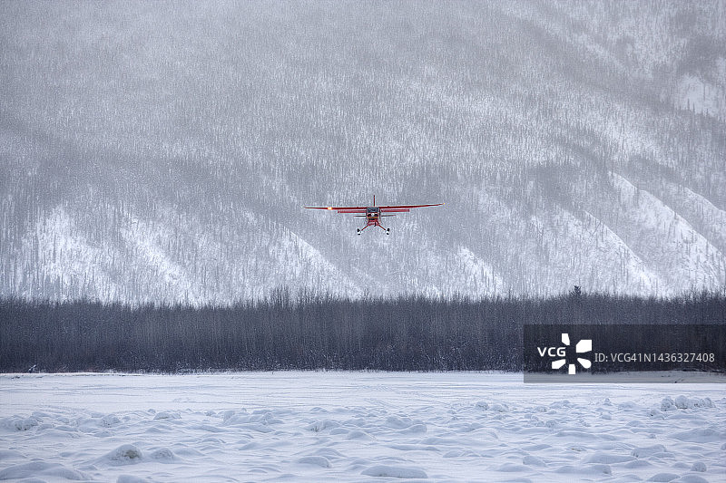 在冰冻的河面上降落的丛林飞机图片素材