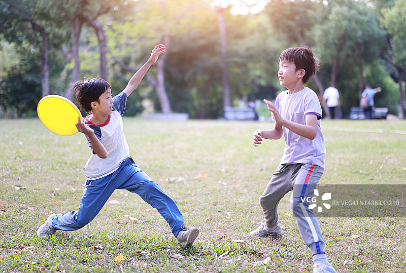 小男孩在公园里玩飞盘图片素材