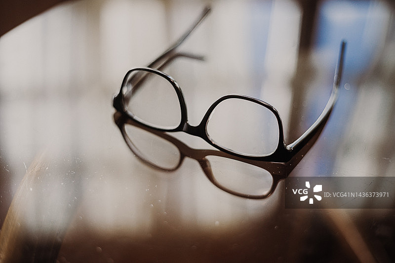 家中桌子上带阴影的眼镜图片素材