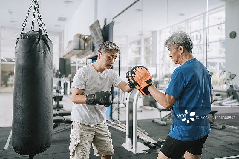 中国老年男子在健身房进行拳击训练图片素材