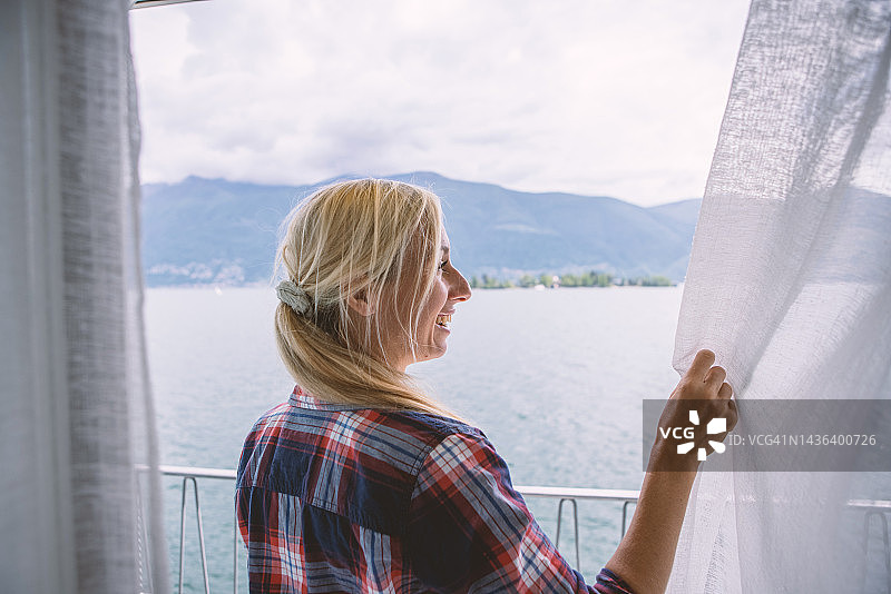 女人在房间里拉开窗帘图片素材