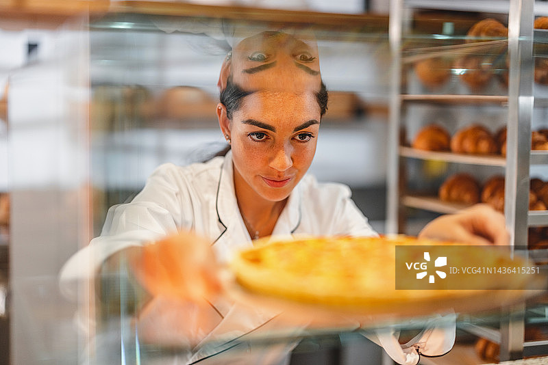 年轻的西班牙裔面包师整理糕点图片素材