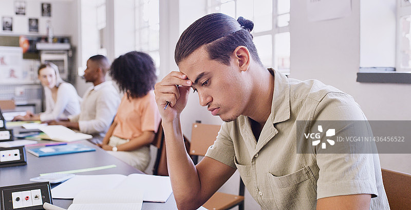 压力、失败与教育：男学生在大学教室考试时遇到学习困难。学习、奖学金和大学：年轻男学生在课堂上感到疲惫图片素材