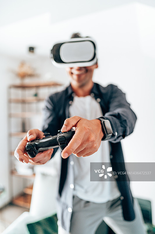 青年男子笑着使用VR模拟器图片素材