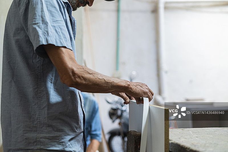 木匠老人正在木工作坊工作图片素材