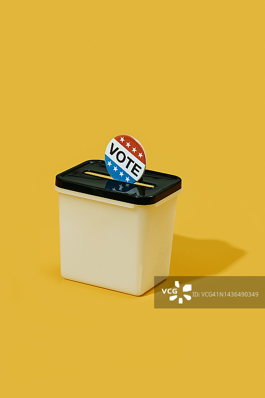 塑料投票箱中的投票徽章图片素材