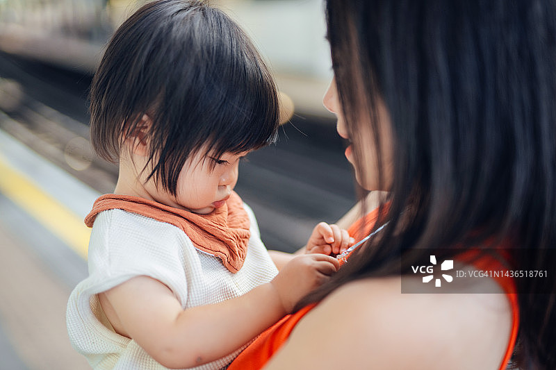 年轻的亚洲母亲抱着女婴，温柔地和她说话特写图片素材