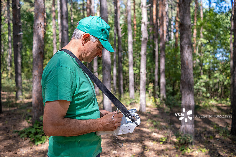 地图制作者在森林中使用专业电脑和GPS编辑地图图片素材