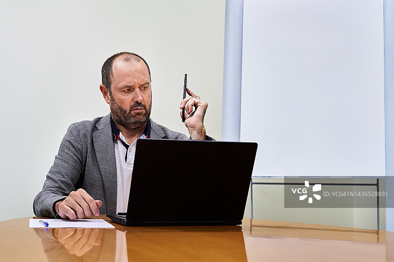 商务人士看手机时困惑的表情图片素材