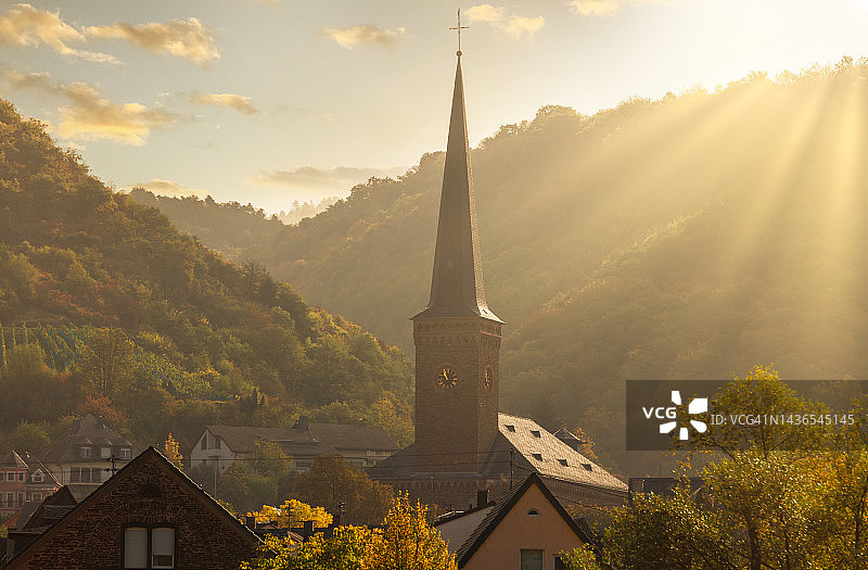 摩泽尔河畔的圣约翰浸信会天主教堂，日出照亮了山间的秋色，莱茵兰-普法尔茨明亮的秋日黎明图片素材