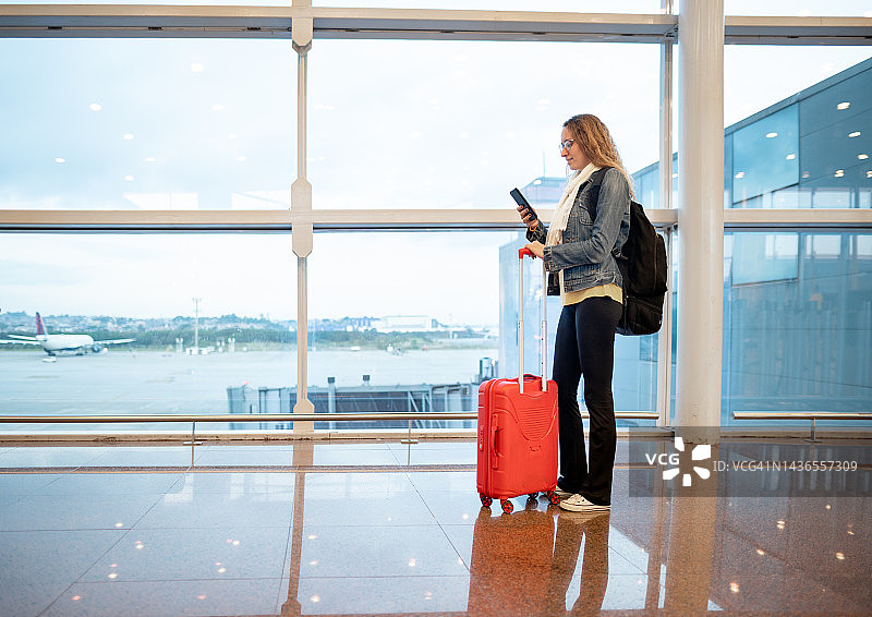 在机场窗边等待航班的年轻女人图片素材