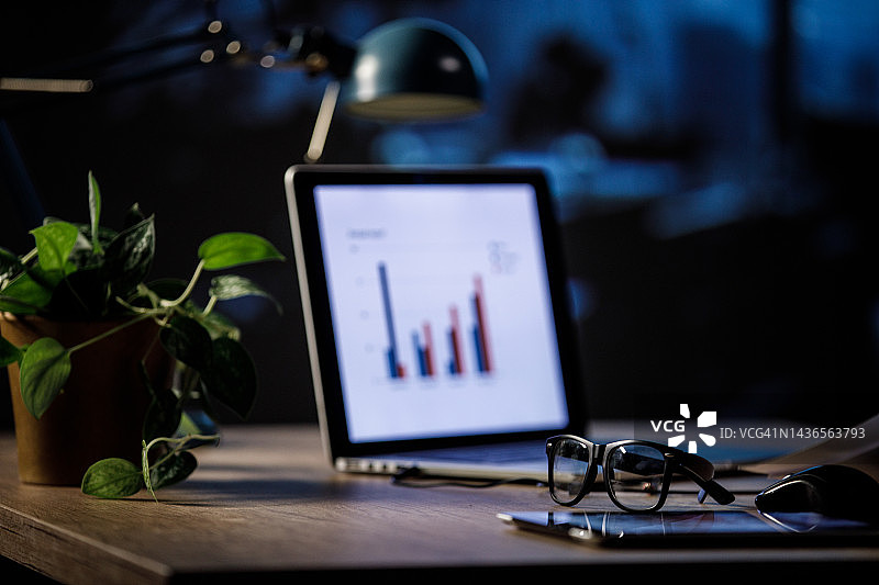 办公室整洁的极简办公桌上的眼镜、笔记本电脑和植物图片素材