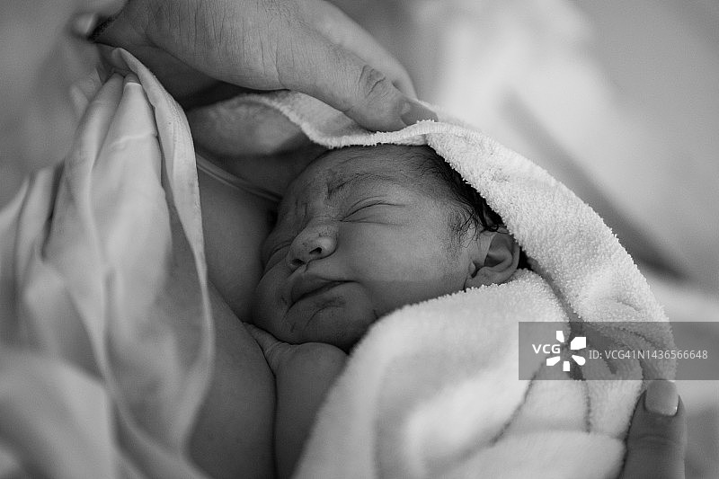 在医院里，分娩后母亲抱着新生婴儿图片素材