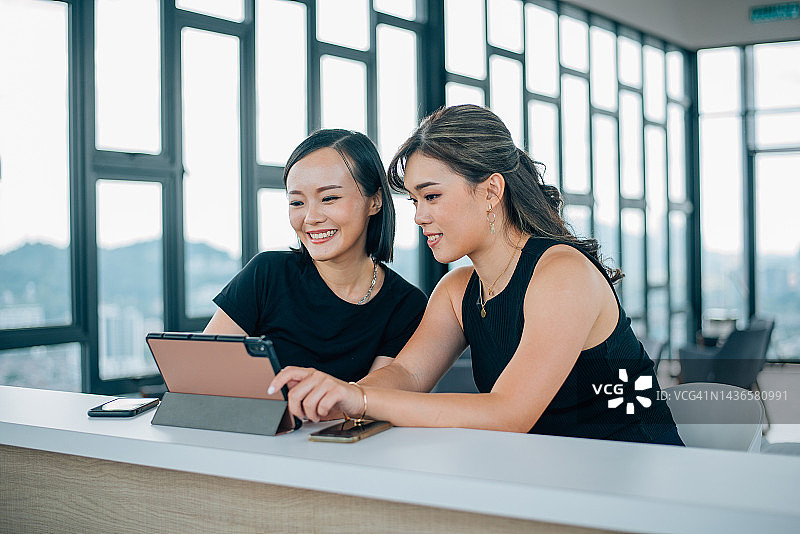 两位亚洲华裔女性正在看数位平板图片素材