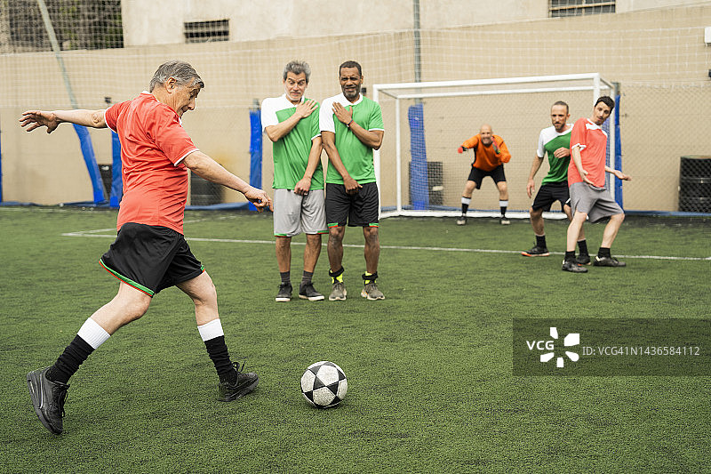 比赛中主罚任意球的成熟足球运动员图片素材