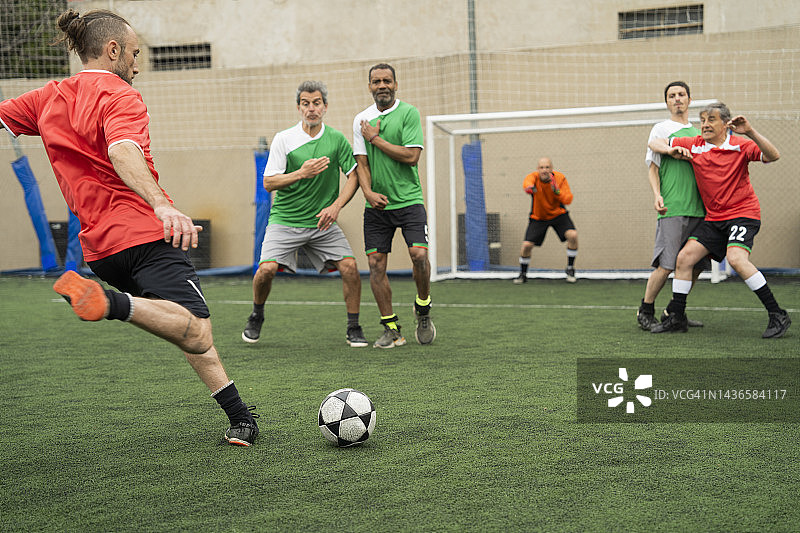 年轻足球运动员在比赛中踢任意球图片素材