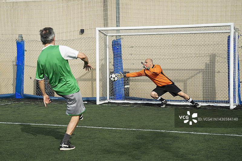 男守门员在足球运动员罚球后接球图片素材