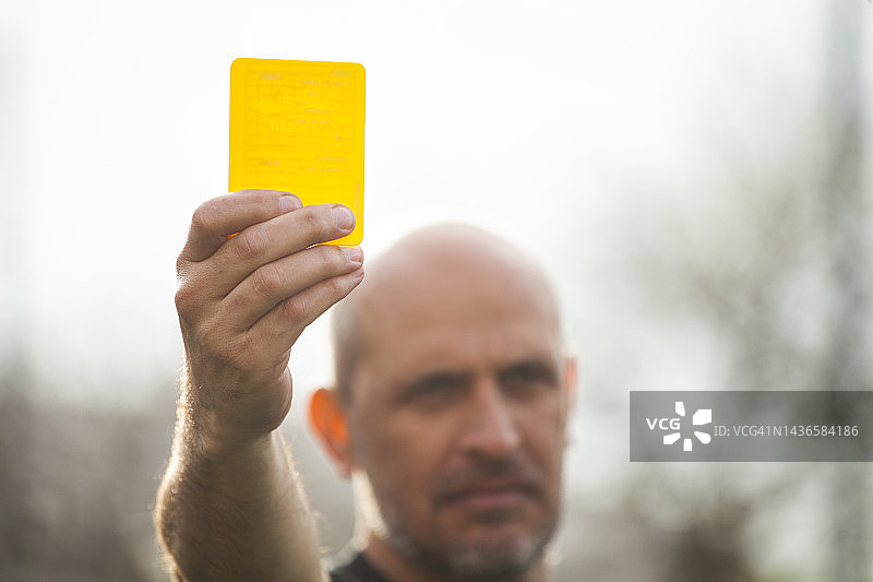 业余足球比赛裁判向球员出示黄牌警告犯规图片素材