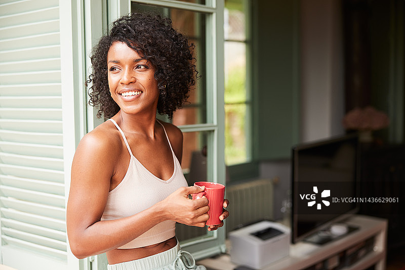 享受清晨咖啡，看着孩子们在外面玩耍图片素材