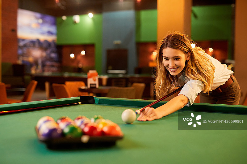 瞄准台球的年轻女人图片素材