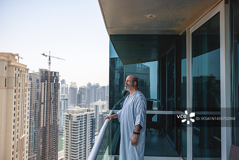 站在阳台上欣赏风景的中东老年男子图片素材