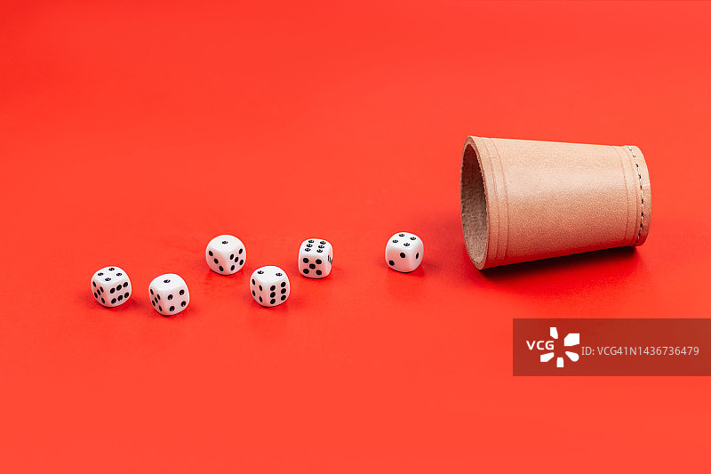 红色背景上从骰盅中洒出的骰子图片素材