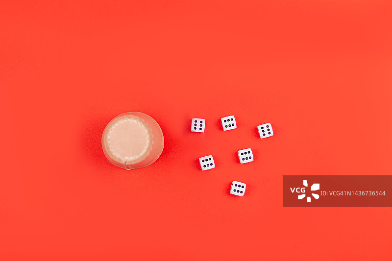 红色背景上的骰盅和骰子图片素材