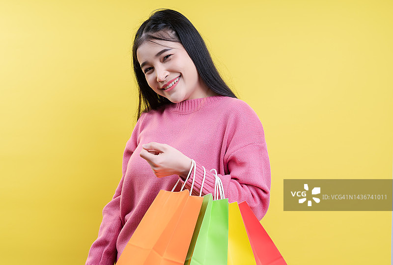拿着购物袋的兴奋女孩肖像图片素材