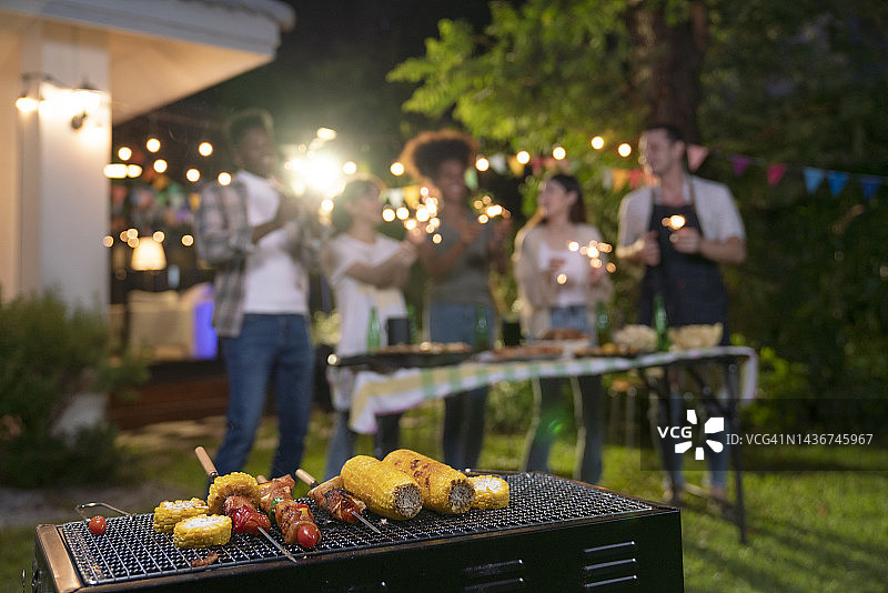 一群快乐的不同种族朋友在后院一起烧烤聚会图片素材