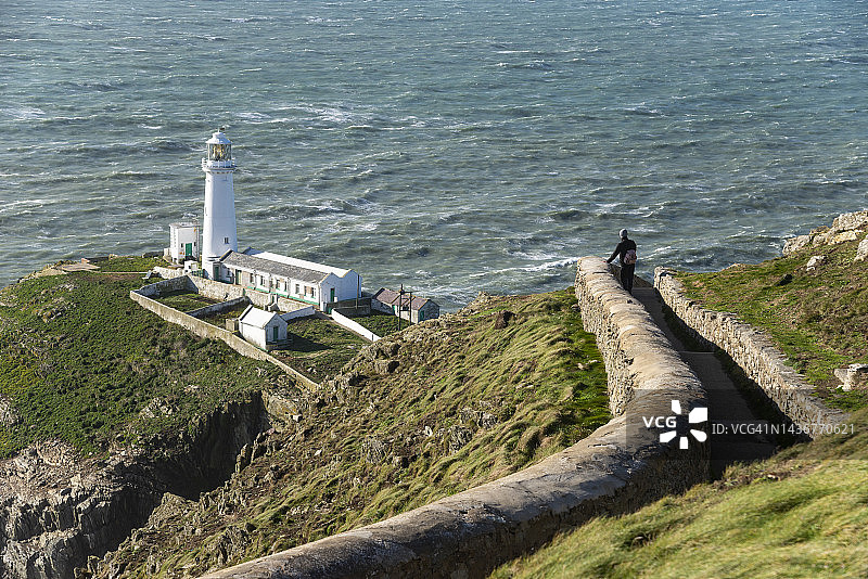 男人俯瞰着英国安格尔西岛南栈灯塔图片素材