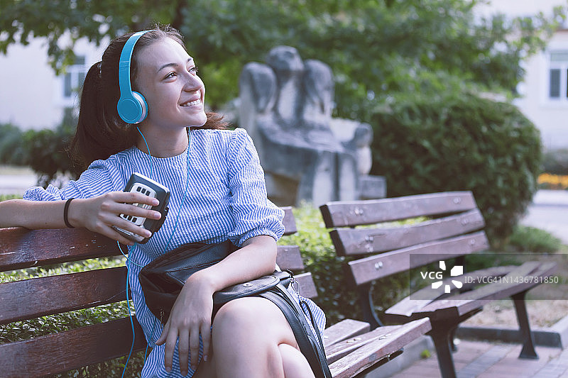 快乐女孩拿着复古卡带播放器图片素材