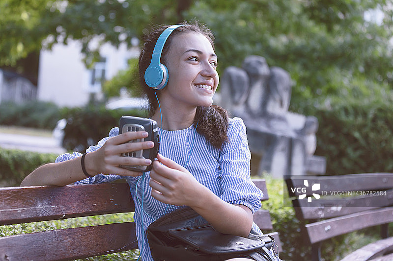 快乐女孩拿着复古卡带播放器图片素材
