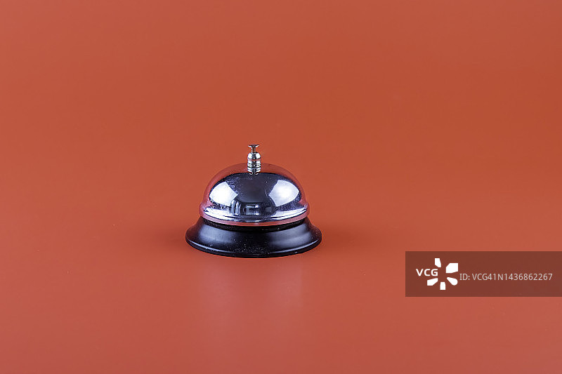 鲜艳红色背景上的银色桌面铃图片素材