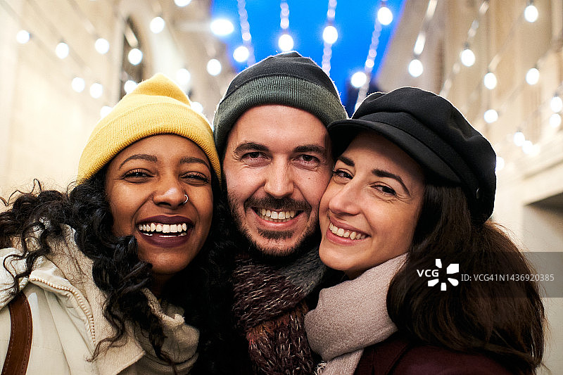 圣诞快乐，三个朋友看着相机特写图片素材