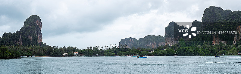 从甲米到皮皮岛的渡轮上拍摄的奥南甲米悬崖和海岸线全景，清晨薄雾中的渡轮驶向热带天堂中的岛屿和泻湖，泰国旅游探险概念图片素材