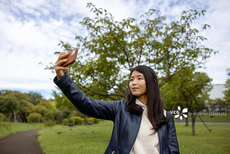年轻女人在公园里自拍图片素材