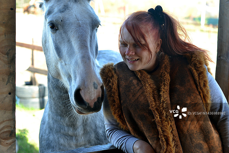 染发的年轻女人和她的马在一起图片素材