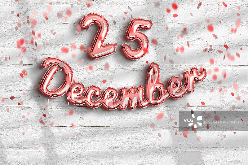 白色砖墙背景上的金色箔气球和彩色纸屑中的12月25日文字图片素材