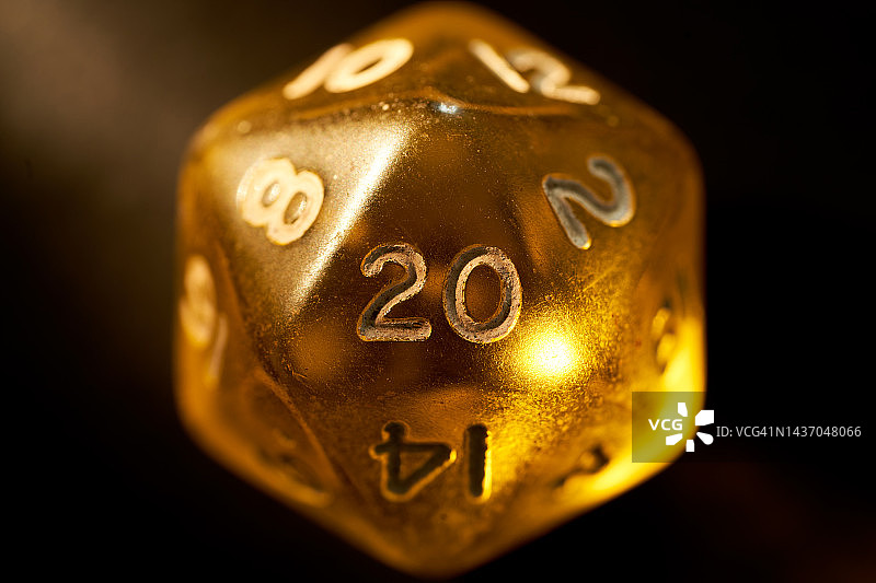 深色背景上的黄色半透明20面角色扮演游戏骰子图片素材