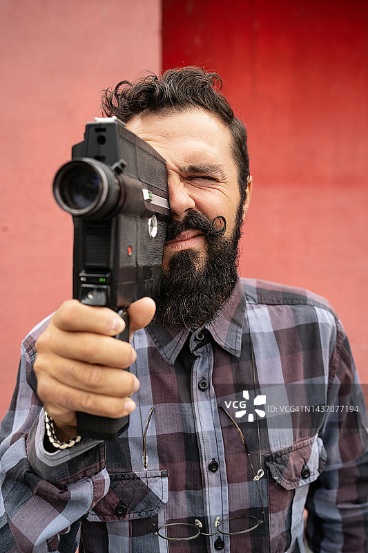 年轻男人用复古相机拍摄视频图片素材