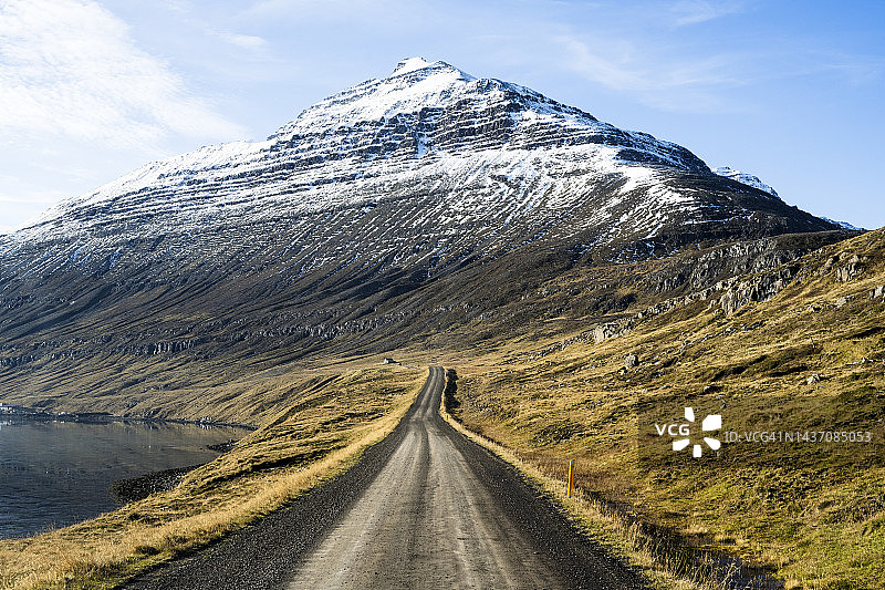 土路和白雪皑皑的山峰图片素材