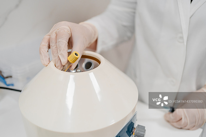 女医生将血液样本放入离心机图片素材
