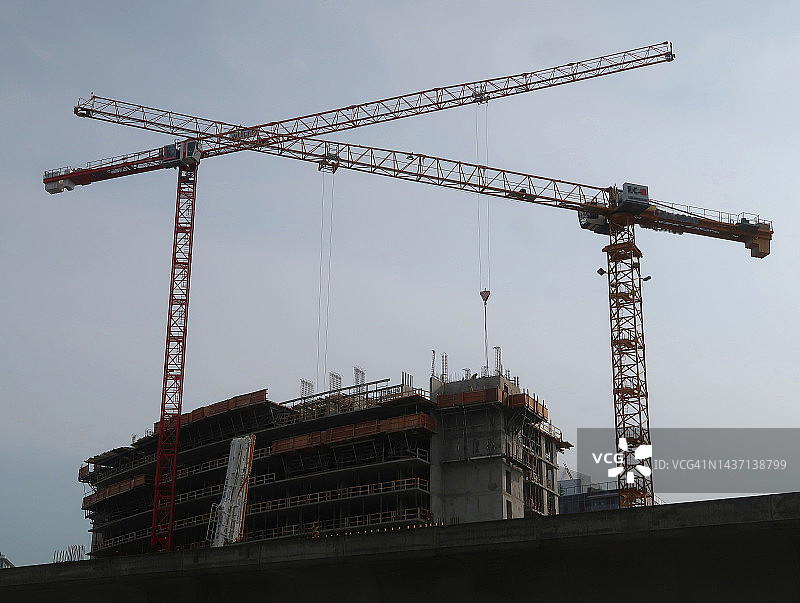 仰望高楼上作业的两台起重机图片素材